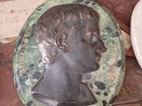 a statue of a man on a stone plate next to a toilet