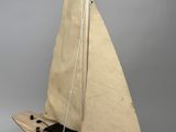 wooden model of a sailboat with a sail on a stand