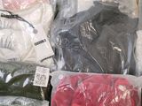 many bags of clothing that are sitting on a table