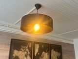 a lamp that is hanging from the ceiling above a bed