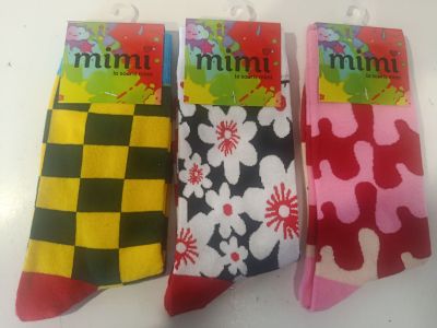 trois paires de chaussettes colorées sont posées sur une surface blanche
