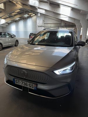 une voiture argentée garée dans un parking couvert avec d'autres voitures
