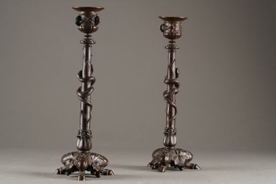 pair of antique silver candlesticks on stand against a gray background