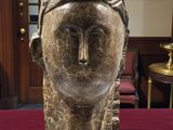 sculpture représentant la tête d'une femme posée sur une table dans une pièce