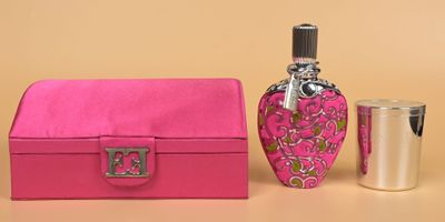 pink box with a bottle of perfume and a shot glass on a table