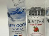 three bottles of vodka are lined up on a white surface