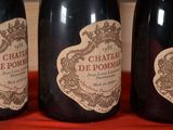 three bottles of wine sitting on a red cloth