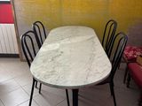 a table and chairs in a room with a yellow wall