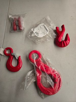 quelques crochets rouges et une paire de ciseaux posés sur une table
