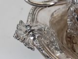 a silver bowl with a handle on it on a table