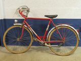 a red bike parked against a blue and white wall