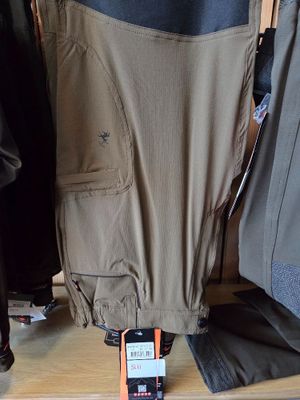 a cell phone sitting on a shelf next to a pair of pants