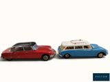two toy cars sitting next to each other on a white surface