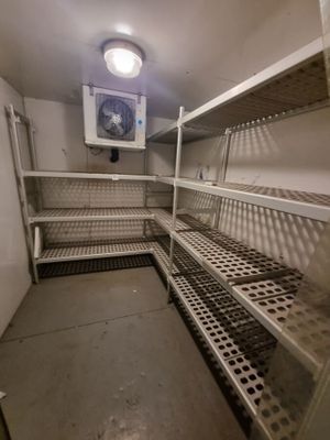 une petite pièce avec de nombreuses étagères et un ventilateur de plafond