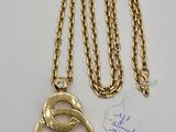 a close up of a gold chain with a ring on it