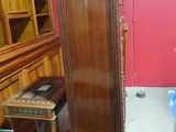 a tall wooden cabinet in the corner of a room