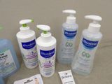 several bottles of hand sanitizer, soap, lotion, and hand sanitizer sitting on a counter