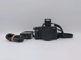 the camera is sitting on a white surface with a black strap