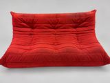un fauteuil futon rouge sur lequel est posé un coussin rouge