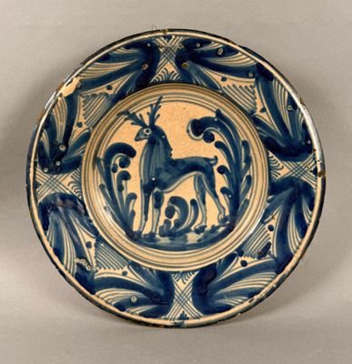 une assiette bleue et blanche sur laquelle est représenté un cerf