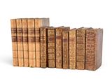 several old books are stacked on top of each other on a white surface