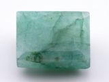 a close up of a green emerald stone on a white surface