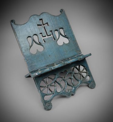a blue metal book stand with a cross on top of it