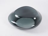 a black glass bowl with a gray base on a white surface