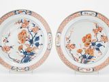 paire d'assiettes chinoises ornées de fleurs et de feuilles, posées sur des socles