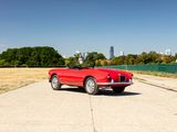 an image of a red convertible car parked on the side of the road