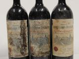 three bottles of wine are lined up on a white surface