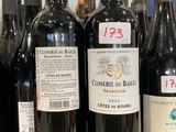 plusieurs bouteilles de vin rouge sont alignées sur une étagère