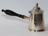 a silver coffee pot with a black handle on a white table