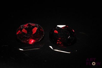 pair of red garnets on a black surface