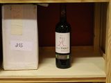 a bottle of wine sitting on a shelf next to a box