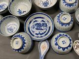 many blue and white dishes and spoons on the table