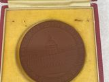an image of a brown medal in a red case