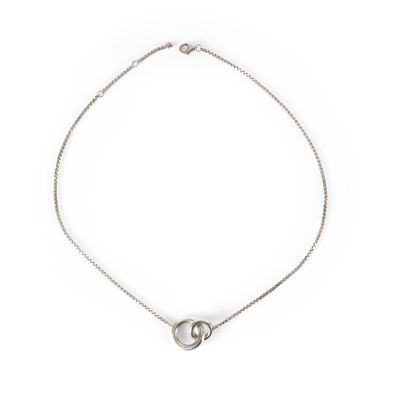 un gros plan d'un collier en argent sur fond blanc