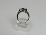 a close up of a ring with a green stone in it
