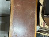 a brown suitcase sitting on top of a pile of boxes