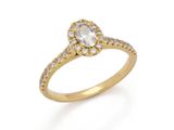 a diamond and gold ring with a pear shaped center