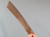 a man holding a large wooden knife in his hand