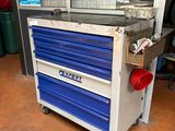 an image of a workbench with blue drawers in a garage
