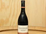 une bouteille de vin posée sur un tonneau