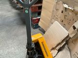 une pile de cartons posée par terre à côté d'un chariot élévateur