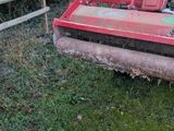 a tractor that is sitting in the grass near a fence