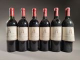 six bouteilles de vin sont alignées sur une table