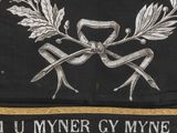 an image of a black and gold banner with a ribbon and laurels on it
