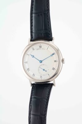 a close up of a wrist watch with a white dial and black leather strap