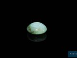 un gros plan d'une pierre de jade verte sur une surface noire